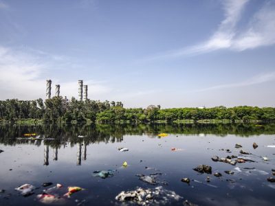 a lake polluted with trash and chemicals from a nearby industrial plant