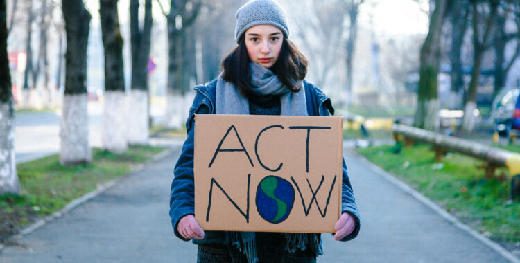 Young woman activist holding a climate change sign that says 